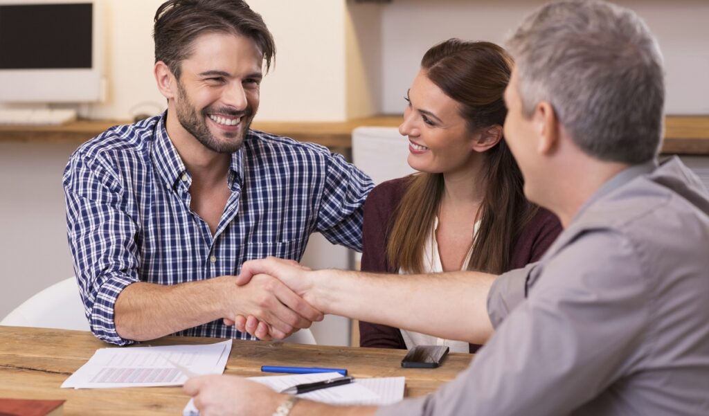 Couple shaking hand to financial agent
